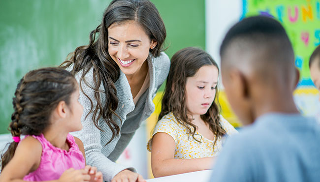 Teacher in classroom assisting students