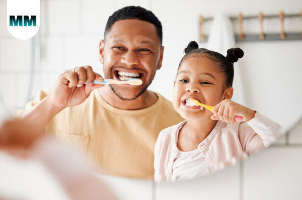 photo of father and daughter brushing their teeth