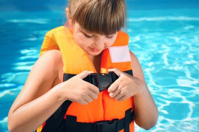 Photo of young girl clipping on a life jacket